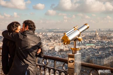 Pareja besándose al lado de un telescopio del mirador de la torre Eiffel, Paris, Francia