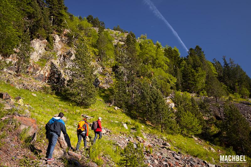 Tres personas caminan por un aruta de montaña en los Pirineos. Ribagorza, Aragón, España