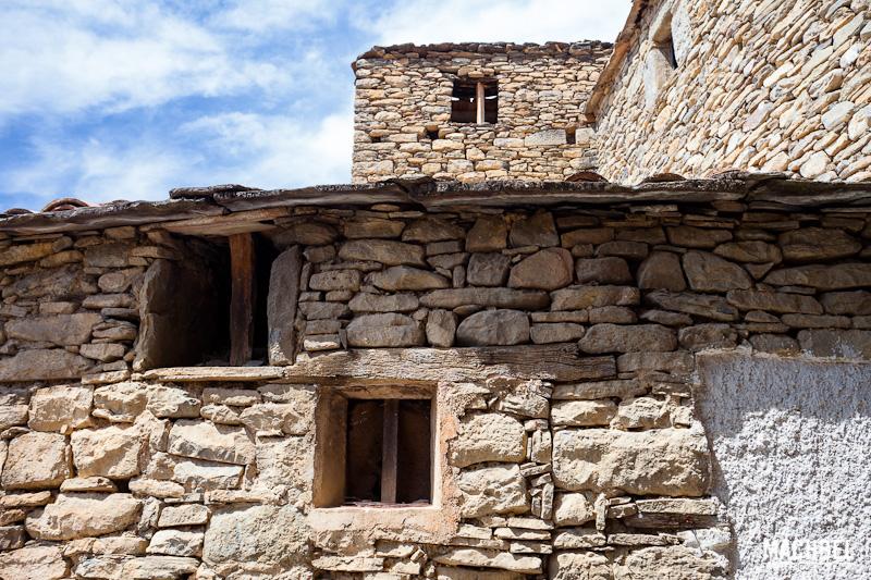 Frontal de una fachada con dos ventanas pequeñas y otra al fondo. Montañana, Aragón, España